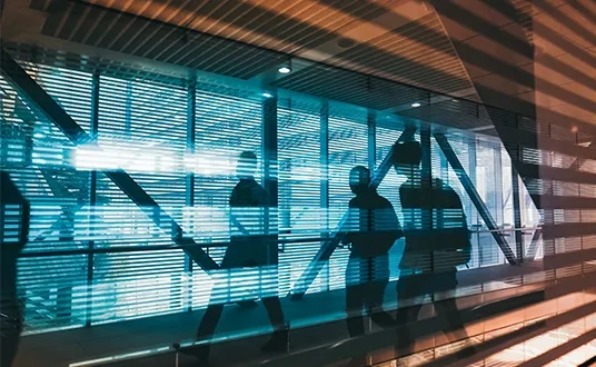 Personen gehen in einem modernen Bürogebäude über den Flur — symbolisch für die HR-Transformation-Beratung von Protiviti